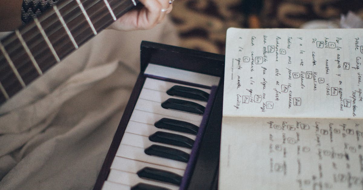 Close-up view of a guitar and keyboard with sheet music, capturing a cozy indoor music session.